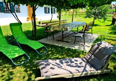 a park with a bench and a table and chairs at Turistična kmetija Hiša ob gozdu pri Ptuju in Ptuj