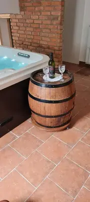a barrel sitting next to a bath tub with a bottle of wine at Turistična kmetija Hiša ob gozdu pri Ptuju in Ptuj