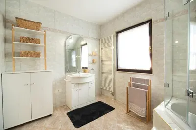 a bathroom with a sink and a mirror and a tub at Pleasant Apartments in Bled
