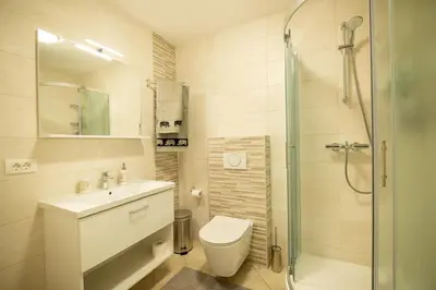 a bathroom with a toilet and a sink and a shower at Pleasant Apartments in Bled
