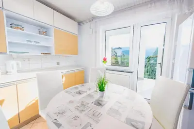 a white kitchen with a table and a window at DREAM BLED Balcony Apartment in Bled