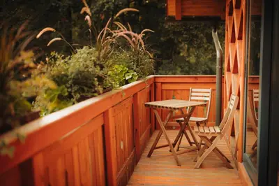 a wooden balcony with a table and chairs on it at Ranč Mackadam Ranch Mackadam in Tržič