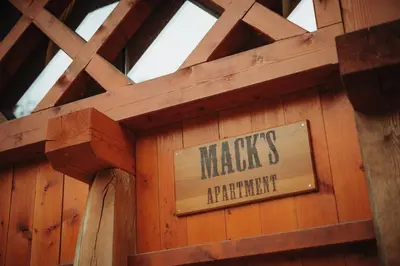 a sign on the side of a wooden wall at Ranč Mackadam Ranch Mackadam in Tržič