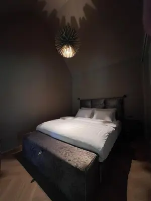 a bed in a dark room with a light at Ranč Mackadam Ranch Mackadam in Tržič