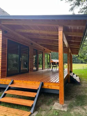 a house with a large wooden deck with a table at Ranč Mackadam Ranch Mackadam in Tržič