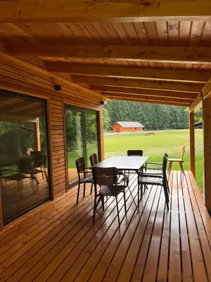 a wooden deck with a table and chairs on it at Ranč Mackadam Ranch Mackadam in Tržič