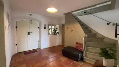 a hallway with a staircase with a chair and a door at Alpine Retreat - Lake Bled in Bled