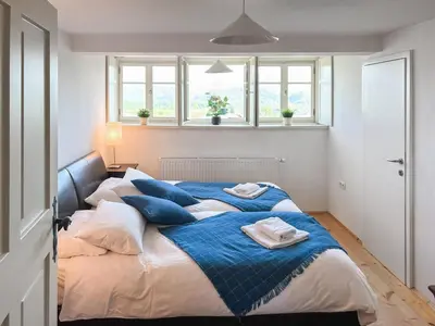 a bedroom with a large bed with blue pillows at Alpine Retreat - Lake Bled in Bled