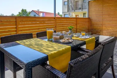 a table and chairs with drinks and food on a patio at Family apartment Moravske Toplice in Moravske Toplice