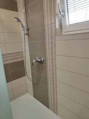 a shower with a shower head in a bathroom at Family apartment Moravske Toplice in Moravske Toplice