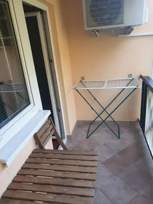 a chair and a table in a room with a window at Aparthotel Rosa - apartma 204 in Podčetrtek