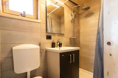 a small bathroom with a toilet and a sink at Glamping Happiness - Natural Pool & Wellness in Ribnica