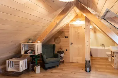 a attic room with a chair and a bathroom at Glamping Happiness - Natural Pool & Wellness in Ribnica