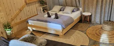 a bedroom with a bed with two pillows at Glamping Happiness - Natural Pool & Wellness in Ribnica
