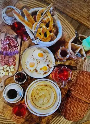 a table topped with plates of eggs and pretzels at Glamping Happiness - Natural Pool & Wellness in Ribnica