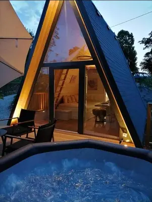 a house with a large window and a swimming pool at NEW! Glamping House with new hot tub and sauna- Hisa oddiha UPDATED DECEMBER 2025 in Smarjeske Toplice