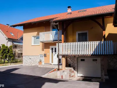 a house with a balcony and a garage at Apartment Activity in Radomlje