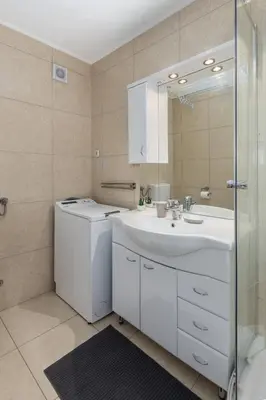 a white bathroom with a sink and a shower at Apartma Valsar Rogla in Zreče