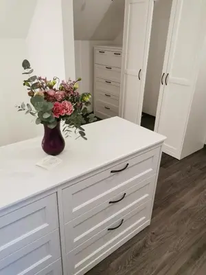 a white counter with a vase of flowers on it at Apartment with mountain view and rivers close by in Šmartno ob Dreti