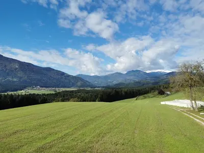 a large green field with mountains in the background at Apartment with mountain view and rivers close by in Šmartno ob Dreti
