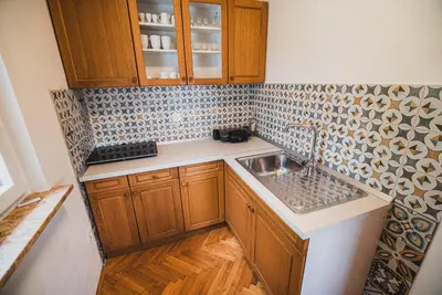 a small kitchen with wooden cabinets and a sink at Holiday Home Liberg with Hot tub and Sauna in Brežice