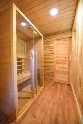 a sauna with a glass door and wooden walls at Holiday Home Liberg with Hot tub and Sauna in Brežice