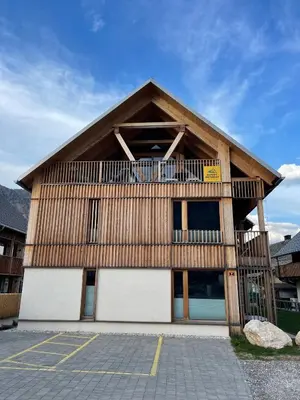 a wooden building with a balcony on top of it at Sunny Retreat Apartment in Kranjska Gora