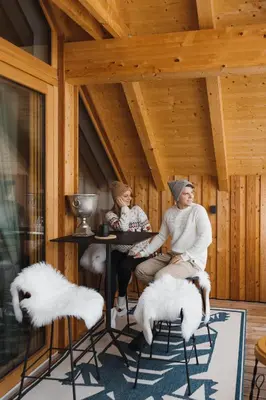 two women sitting at a table in a room at Sunny Retreat Apartment in Kranjska Gora