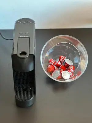 a cell phone next to a bowl of red soda cans at Sunny Retreat Apartment in Kranjska Gora