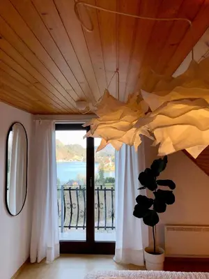 a room with a large window and a ceiling with curtains at Lakeview Guesthouse & Chalet Bled in Bled