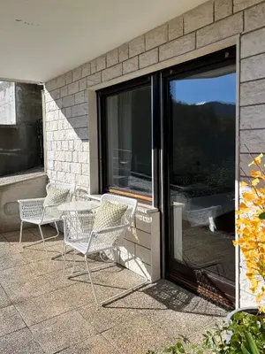 a patio with chairs and a table and a sliding glass door at Lakeview Guesthouse & Chalet Bled in Bled