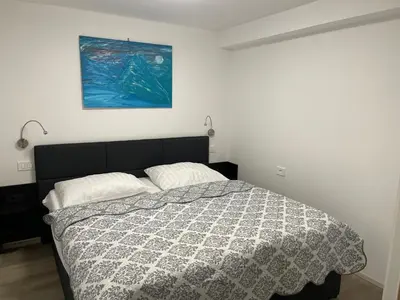 a bedroom with a bed and a painting on the wall at Apartma Toni Bovec in Bovec