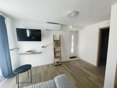a living room with a couch and a tv on the wall at Apartma Toni Bovec in Bovec