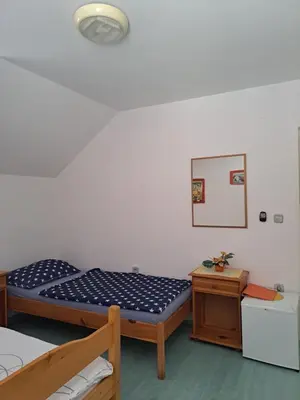 a bedroom with two bunk beds and a table at Rooms Čehovin in Postojna