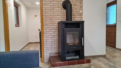 a fireplace in a living room with a brick wall at Radovna Mountain Valley Cottage in Zgornje Gorje
