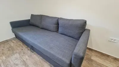 a blue couch sitting in a room next to a wall at Radovna Mountain Valley Cottage in Zgornje Gorje