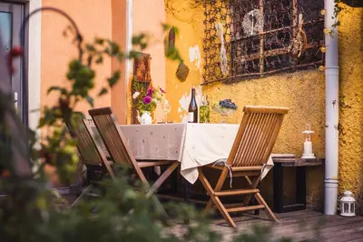 a table with two chairs and a table with flowers at BELAKAPA Authentic house with garden and free parking in Ilirska Bistrica
