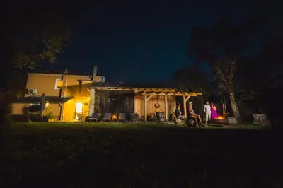 a group of people standing outside a house at night at BELAKAPA Authentic house with garden and free parking in Ilirska Bistrica