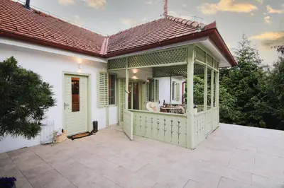 a green and white house with a patio at Vila Vilma Vineyard Cottage in Lendava