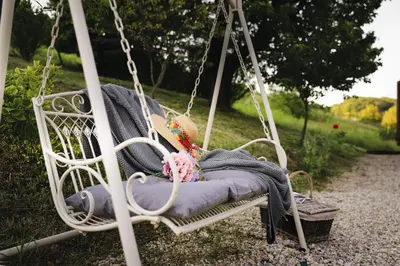 a swing in a yard with a blanket and a towel at Vila Vilma Vineyard Cottage in Lendava