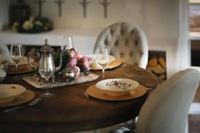 a wooden table with wine glasses and a plate of food at Vila Vilma Vineyard Cottage in Lendava