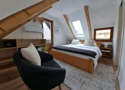 a bedroom with a bed and a chair at Captain's Lodge in Bohinj