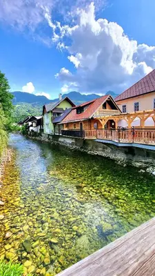 a group of buildings next to a river at Captain's Lodge in Bohinj