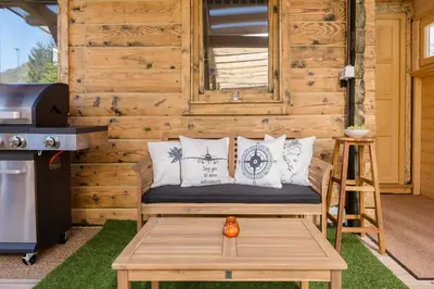 a bench with pillows and a table in front of a cabin at Captain's Lodge in Bohinj