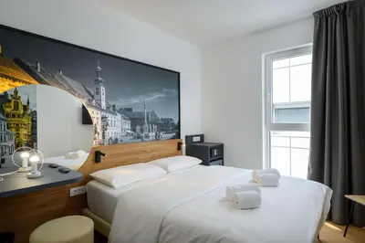 a hotel room with two beds and a picture on the wall at B&B Hotel Maribor in Maribor