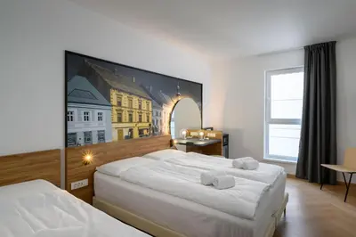 a bedroom with two beds and a painting on the wall at B&B Hotel Maribor in Maribor