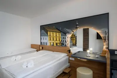 a bedroom with a large picture of a city at B&B Hotel Maribor in Maribor