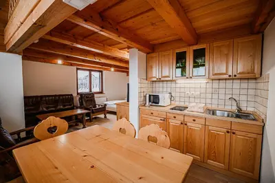 a kitchen with wooden cabinets and a wooden table at Vineyard Cottage Maleric with Pool Access in Dragatuš