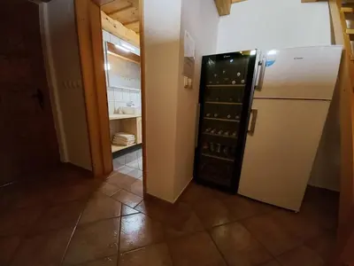 a kitchen with a refrigerator with wine bottles at Vineyard Cottage Maleric with Pool Access in Dragatuš