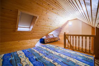 a bedroom with a large bed in a wooden room at Vineyard Cottage Maleric with Pool Access in Dragatuš